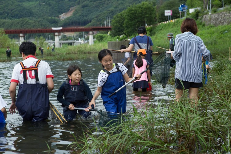지난 7월, 중앙내수면연구소 탐방 후 지구사랑탐사대 대원들이 조종천에서 민물고기 현장교육을 진행하고 있는 모습. - AZA studio 제공 제공